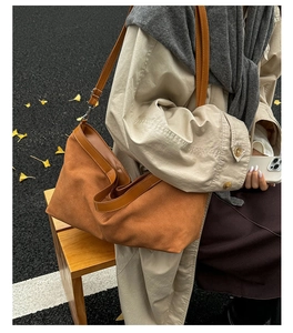 Dettaglio della borsa tote in pelle scamosciata marrone con texture morbida e tracolla