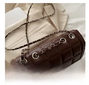 Detailed view of the dark brown quilted leather cylinder bag with chain strap