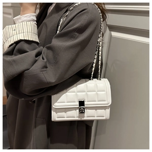 Detail of white quilted crossbody bag with silver metal buckle and chain strap