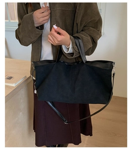 Dettaglio della borsa tote in pelle scamosciata nera con tracolla in pelle e finitura