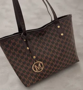 Nahaufnahme der braunen Shopper-Tasche aus Kunstleder mit M-Muster und Metallanhänger