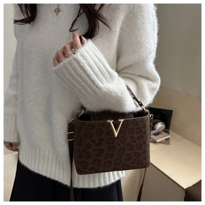 Detail of leopard print handbag with gold V logo shown in a lifestyle setting