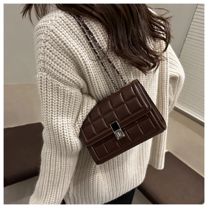 Detail view of deep brown quilted shoulder bag with chain strap and metallic clasp