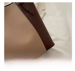 Close-up of the fine stitching and two-tone leather texture on this stylish tote bag