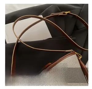 Close-up of adjustable leather shoulder strap and woven texture bucket bag with metal buckle