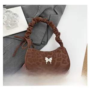 Detail of leopard print shoulder bag with silver butterfly clasp on a grey blazer