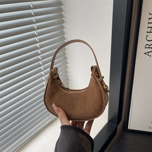 Borsa a mezzaluna in camoscio marrone con dettagli dorati e manico minimalista elegante
