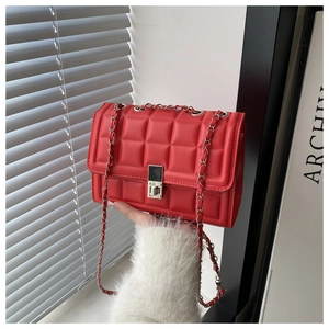 Detailed macro view of red quilted PU leather texture and silver metallic twist-lock