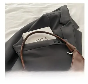 Detailed view of the comfortable leather handle on a vintage brown crescent bag