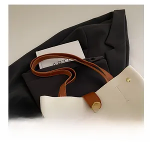 Détail du sac cabas bicolore avec poignées en cuir marron et boucle en métal doré