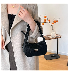 Close-up of black leopard texture underarm bag with silver butterfly buckle and scrunchie handle