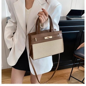 Détail du sac cabas bicolore avec texture cuir et fermoir rotatif doré élégant