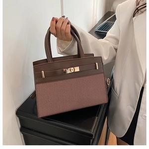 Vue détaillée du sac à main marron bicolore avec fermoir doré rotatif et texture tissée