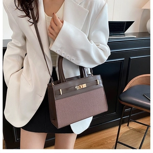 Vue détaillée du sac à main marron contrasté avec fermoir doré et bandoulière en cuir