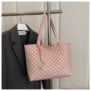 Detailansicht der rosa Tragetasche mit M-Monogramm-Muster und goldenem Metallanhänger