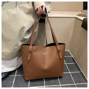 Close-up of brown tote bag with gold metal buckle and Tidal Dryness Bags text logo