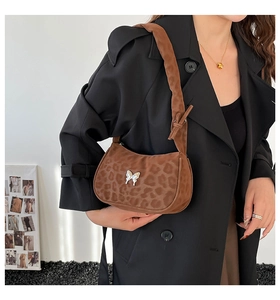 Chic leopard print shoulder bag with butterfly buckle detail styled on a model in a blazer