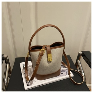 Detail of a vintage contrast bucket bag with gold hardware on a minimalist magazine