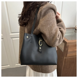 Détail du cabas noir avec rivets dorés et boucle à anneau sur cuir mat texturé de luxe