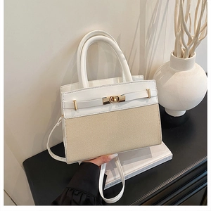 Détail du sac à main en cuir et paille avec fermoir rotatif doré et deux poignées