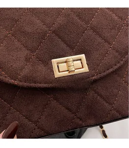 Macro shot of brown suede quilted texture and golden rectangular twist lock detail