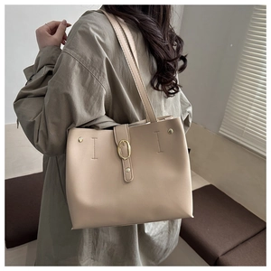 Détail du sac cabas beige avec boucle dorée et finition en similicuir à texture fine
