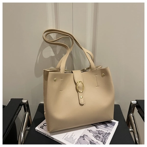 Détail de la boucle dorée et des rivets sur le sac fourre-tout minimaliste couleur crème