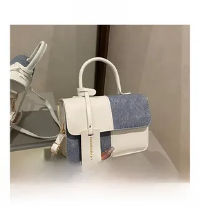 Detail der Handtasche mit weißem Leder und blauem Denim in stilvoller Farbkombination