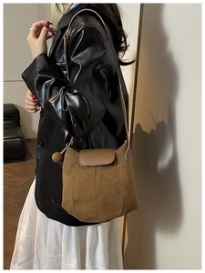 Detail of vintage brown suede bucket bag featuring a unique multi-panel stitched design