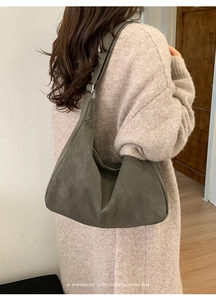 Detailed side view of an olive green hobo bag featuring adjustable silver hardware strap