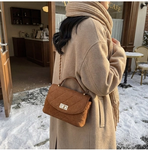 Brown quilted suede handbag with gold chain strap shown in a winter street style scene