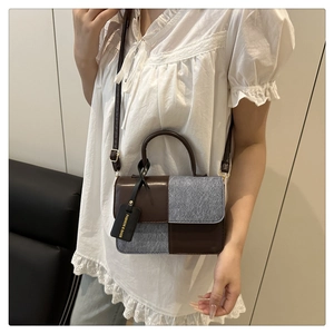 Detailaufnahme einer Umhängetasche aus braunem Leder und grauem Filz am Modell