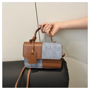 Detail der Kontrastfarbe Handtasche mit braunem PU-Leder und grauer Denim-Struktur