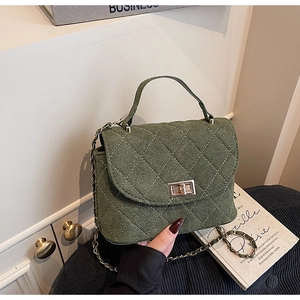 Detail of olive green quilted handbag featuring a matte texture and gold turn-lock closure