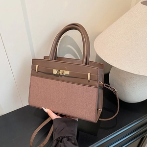 Sac à main marron en cuir et tissu avec fermoir doré et bandoulière réglable pratique