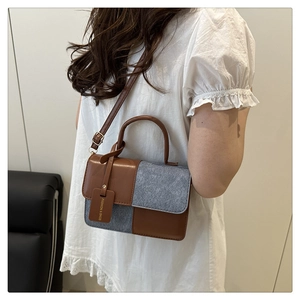 Detailansicht der Nähte aus braunem Leder und grauem Filz an einer Damen-Schultertasche