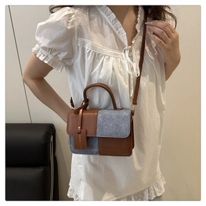 Details der zweifarbigen Mini-Umhängetasche aus braunem Leder und grauem Filzstoff