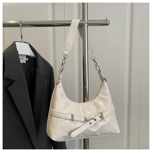 Detail of creamy white crescent shoulder bag with silver hardware and belt strap buckle