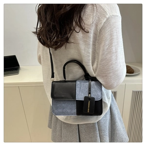 Detail einer kontrastierenden grauen Tweed- und schwarzen Ledertasche an einem Modell