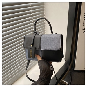 Detail der Kontrast-Handtasche mit verstellbarem Riemen und modischem Anhänger