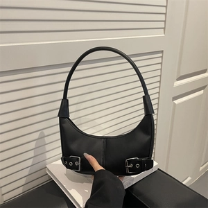 Minimalist black crescent shoulder bag with silver buckle details on white background