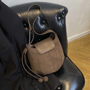 Chic brown frosted suede bucket bag with leather trim and decorative spherical charm