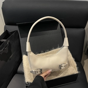 Minimalist cream leather crescent shoulder bag with silver buckle details and wide strap