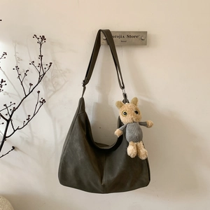 Retro olive green oversized suede tote bag with plush charm and wide shoulder strap