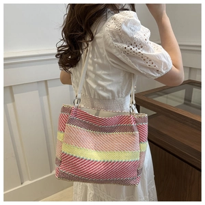 Détail du sac bandoulière tissé à rayures colorées avec sangle en cuir blanc et boucle argent