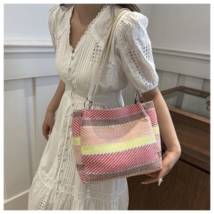 Détail d'un sac à bandoulière tissé à rayures colorées avec anneaux en métal et fines anses