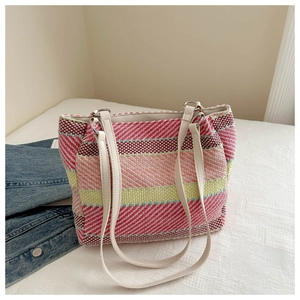 Détail d'un sac cabas tissé à rayures colorées avec bandoulière en cuir crème