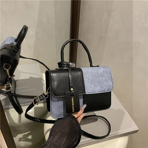 Chic color-block denim and black leather crossbody handbag with gold hardware