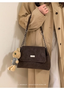 Chic dark brown leather shoulder bag with metal plate and plush rabbit charm detail