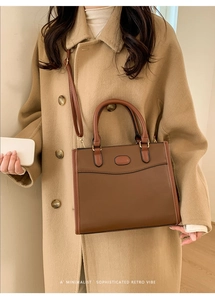 Bruine lederen handtas met minimalistisch retro-ontwerp op beige achtergrond